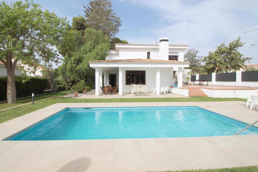 a villa with a swimming pool in front of a house at Del Parque Flats Villa Sauce in Chilches