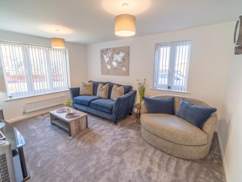 ein Wohnzimmer mit 2 Sofas und einem TV in der Unterkunft Pass the Keys Centrally located beautiful 3 bed new build home in Nottingham