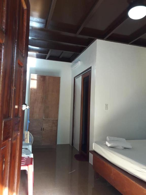 a bedroom with a bed and a door to a room at Bearby's Homestay Siargao - RH in Catangnan