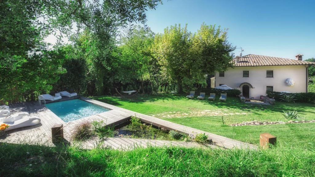 a backyard with a swimming pool and a house at LA DAMA DEL BOSCO 8&3, Emma Villas in Capriglia