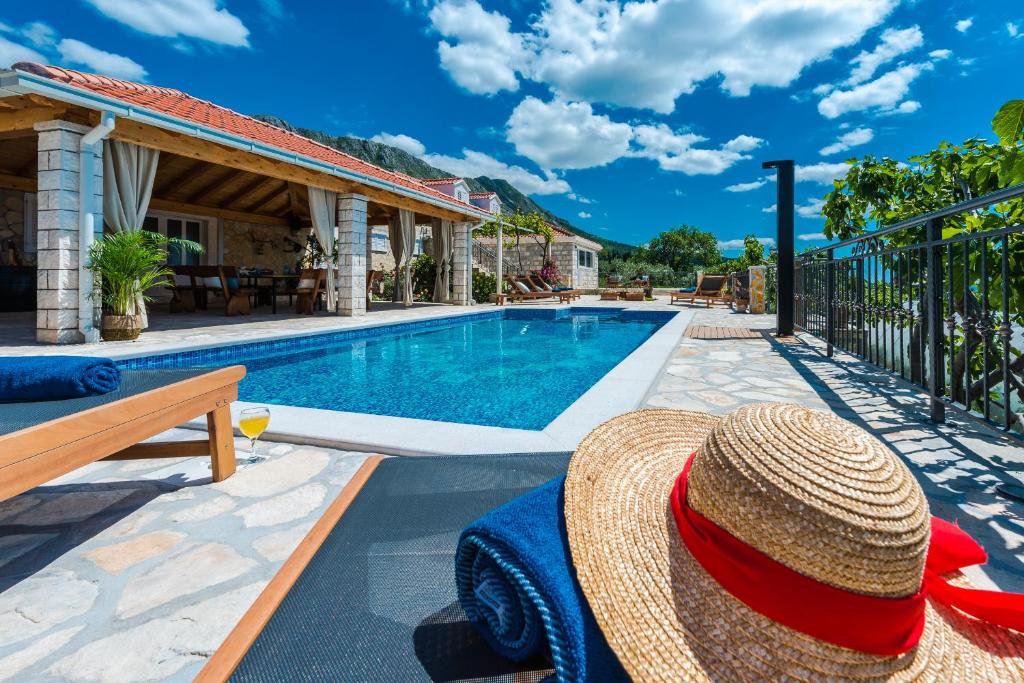un sombrero de paja sentado junto a una piscina en Villa Paulina, en Mlini