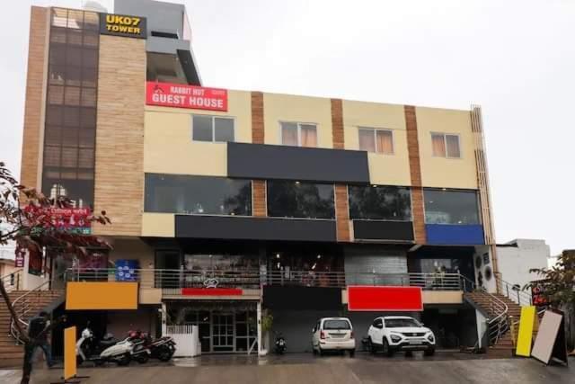 a building with cars parked in front of it at Hotel Rabbit Hut in Dehradun