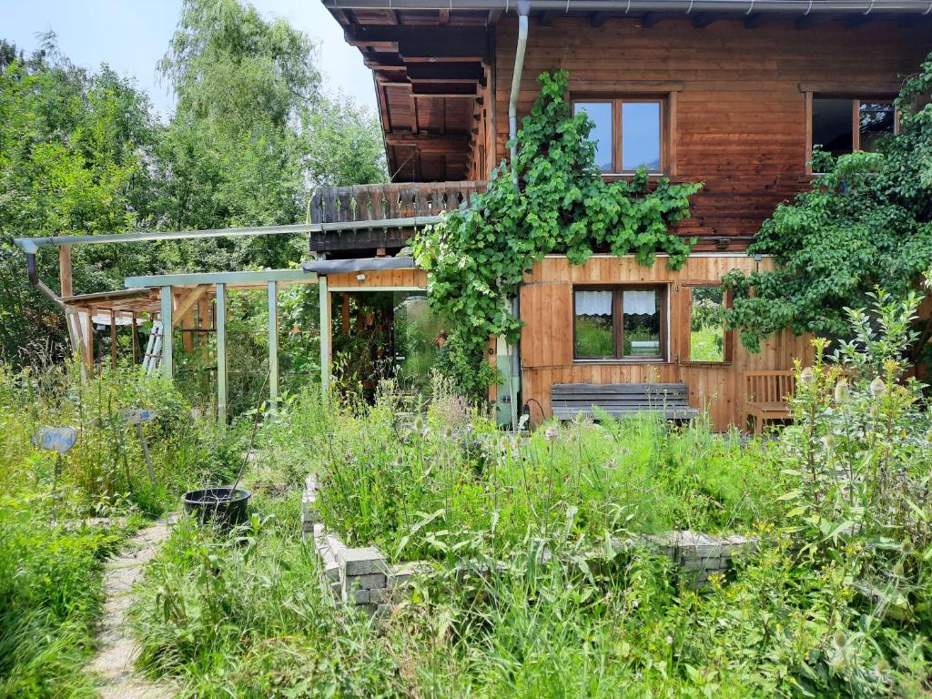 una casa de madera con un jardín delante de ella en Bauernhaus im Permakultur-Garten en Sankt Johann in Tirol