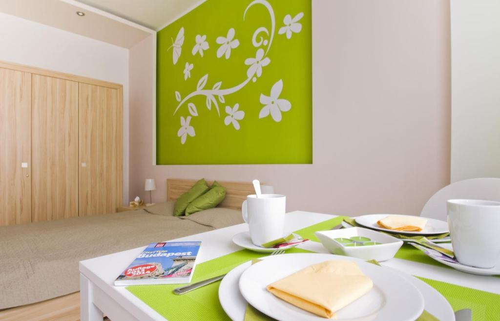 a dining room table with a green painting on the wall at Régiposta Studio in Budapest