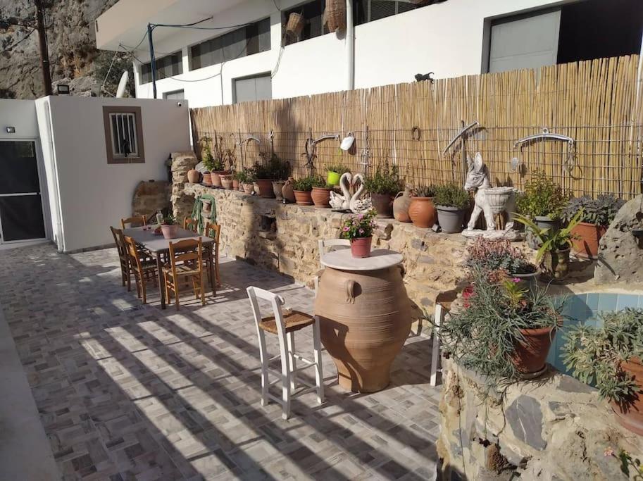 un patio con mesa, sillas y macetas en MARINOS House WANDERN&ENTSPANNEN am Fusse des Psiloritis, 
