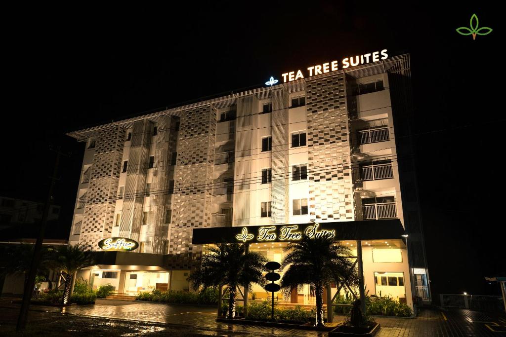 瑪尼帕拉的住宿－Tea Tree Suites,Manipal，带有阅读茶树套房标志的酒店建筑