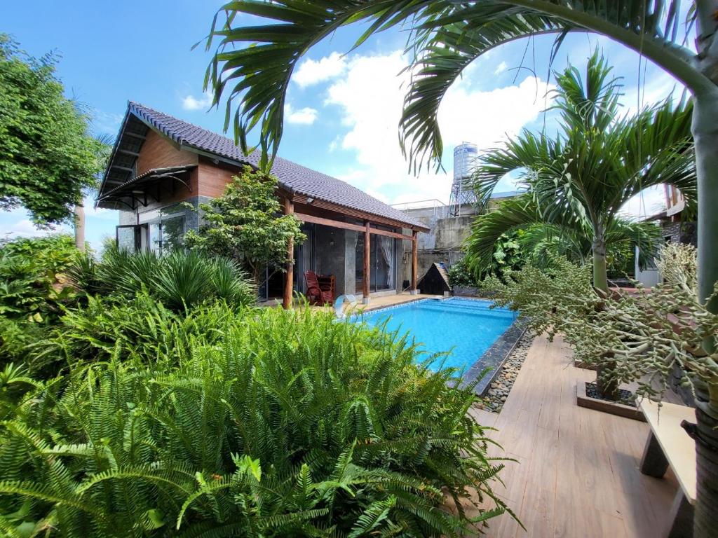 una casa con piscina en un jardín en T'Farmstay villa and resort Buon Ma Thuot City, en Buon Ma Thuot