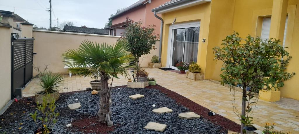 un patio de una casa con árboles y rocas en Gite Ray ., en Brévonnes