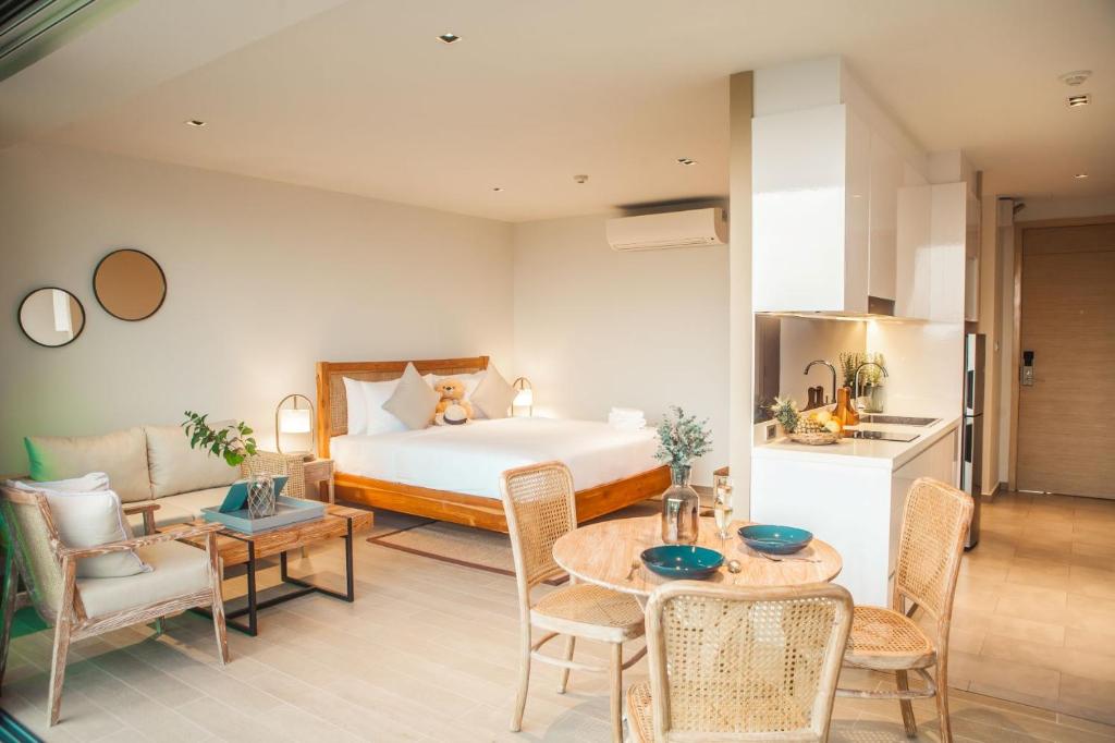 1 dormitorio con 1 cama, mesa y sillas en Fisherman House Residence Pranburi en Sam Roi Yot