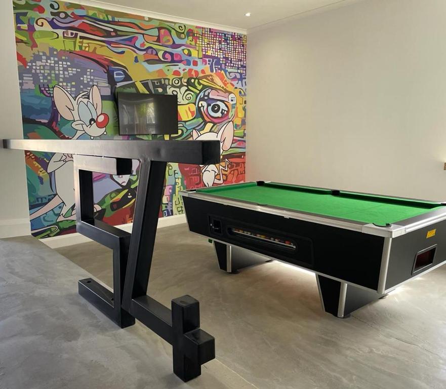 a pool table in front of a colorful wall at The Door RSA Fifty-Four in Plettenberg Bay