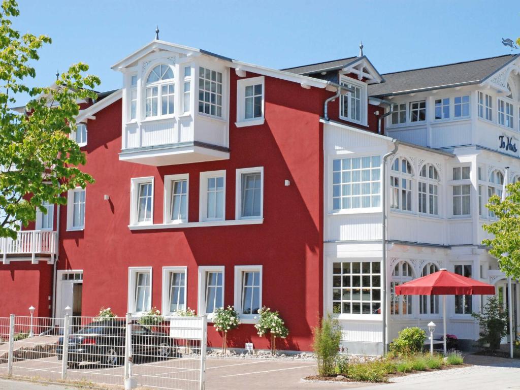 ein rotes Gebäude mit weißen Fenstern in der Unterkunft Villa "To Hus" F590 - Appartement 05 im Dachgeschoss mit Himmelbett, Kamin und Balkon in Ostseebad Sellin