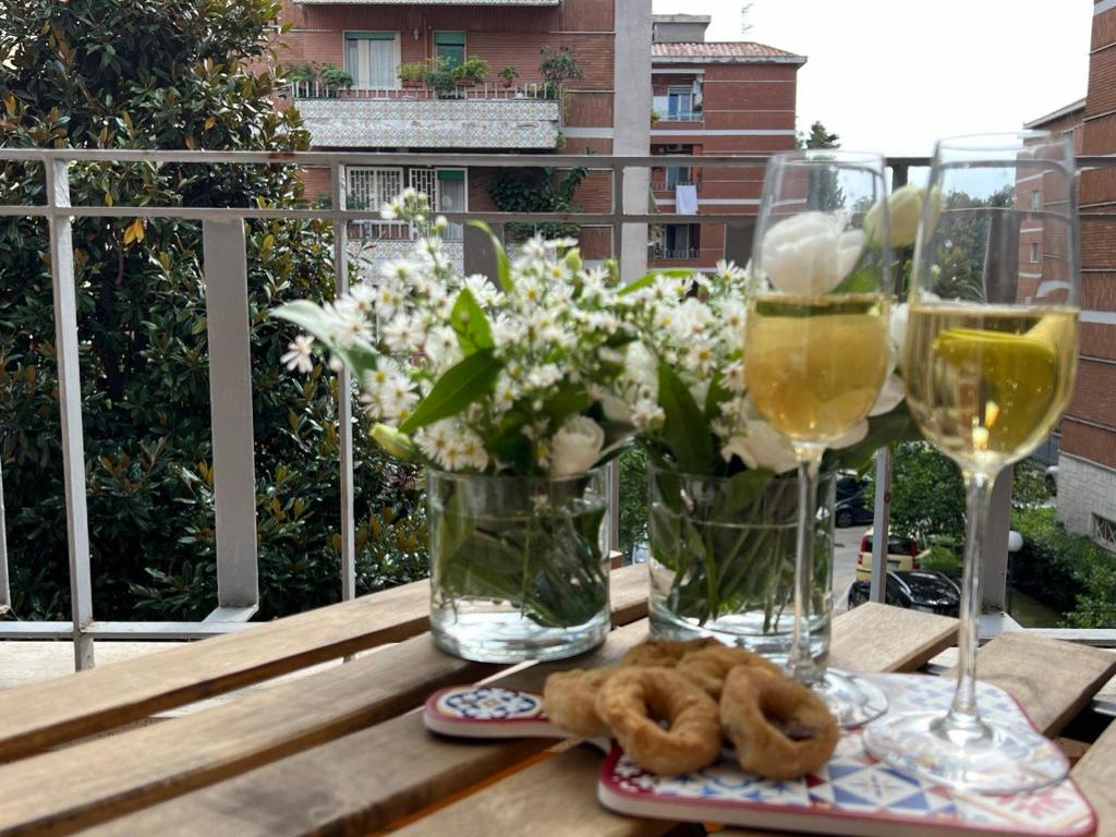 a table with glasses of wine and some donuts and flowers at Ma Petite Maison in Naples