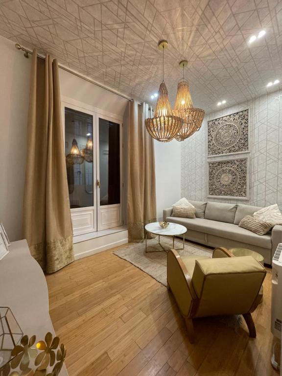 ein Wohnzimmer mit einem Sofa und einem Stuhl in der Unterkunft Apartamento cerca Plaza Mayor in Madrid