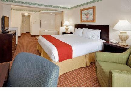 a hotel room with a large bed and a chair at Holiday Inn Express Hotel & Suites Easton by IHG in Easton