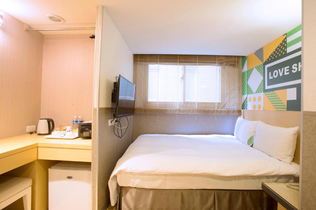 a small room with a bed and a desk at Ximen Citizen Hotel in Taipei