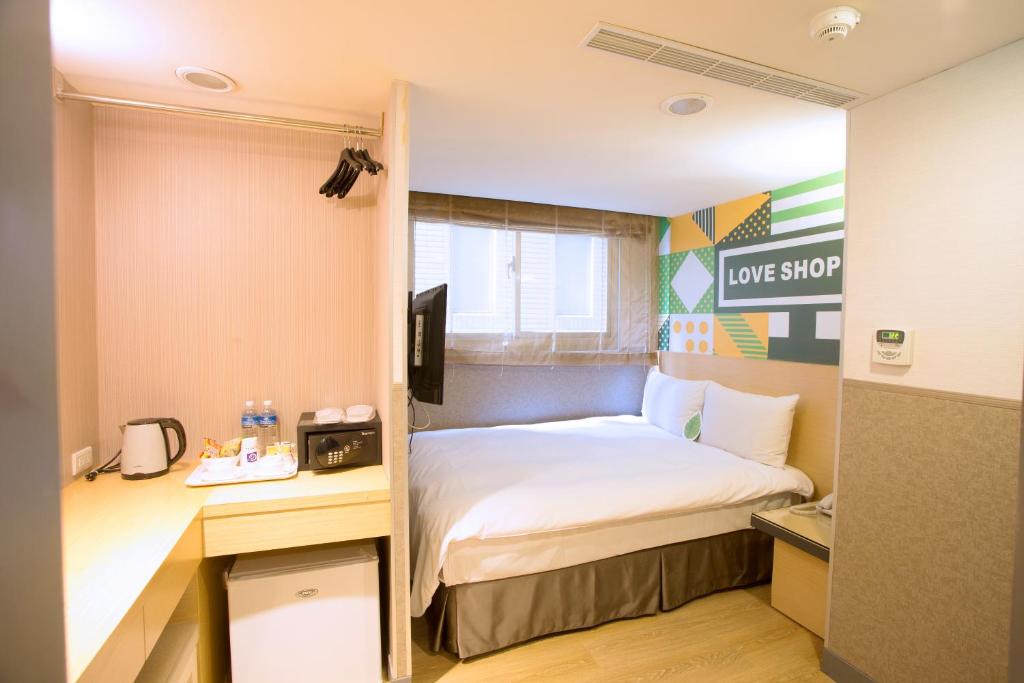 a hotel room with a bed and a desk and a bed sidx sidx sidx sidx at Ximen Citizen Hotel in Taipei