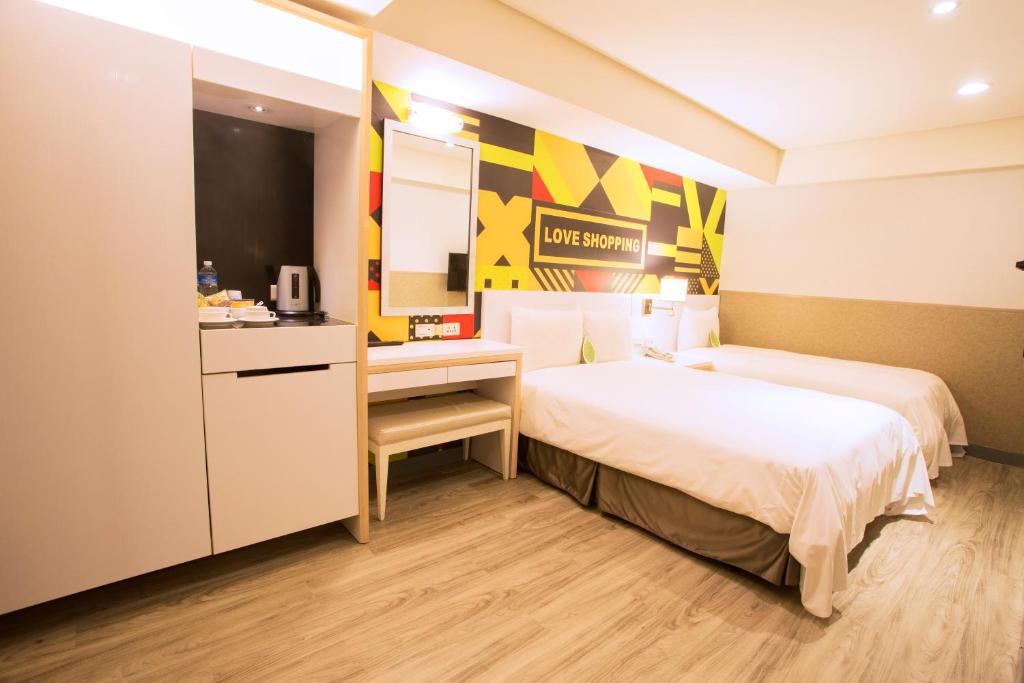 a hotel room with two beds and a kitchen at Ximen Citizen Hotel in Taipei