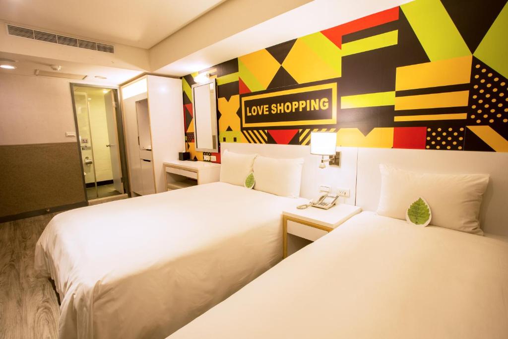 a hotel room with two beds and a sign that reads love shopping at Ximen Citizen Hotel in Taipei