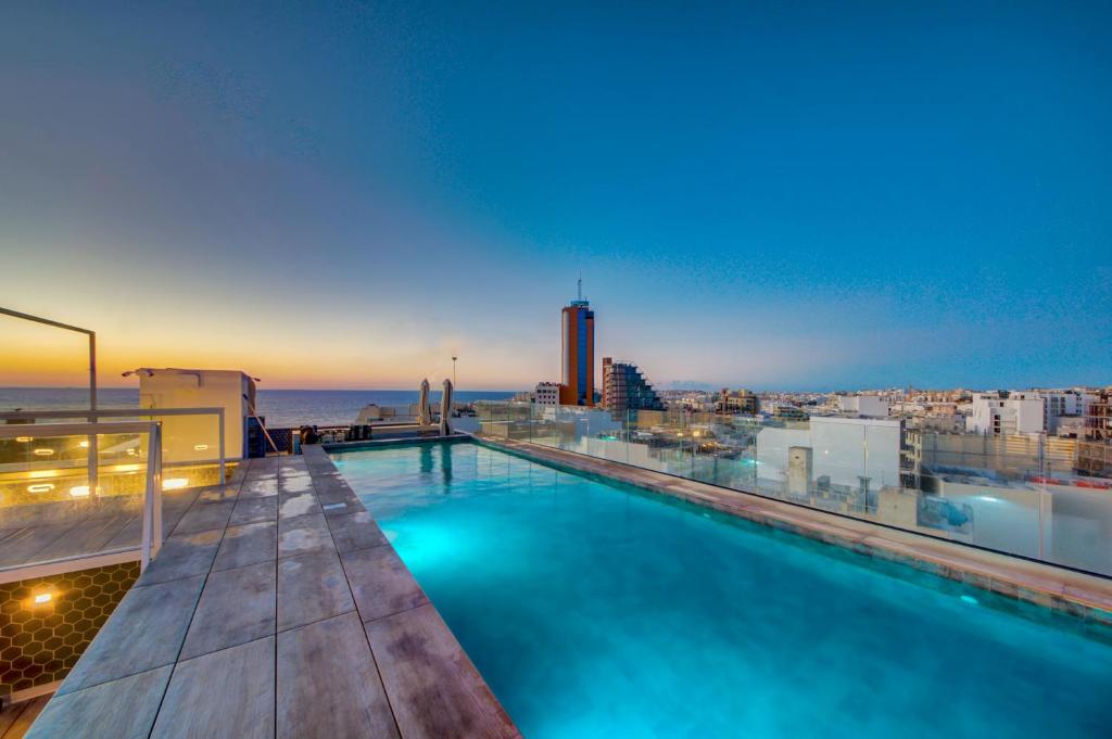 a swimming pool on the roof of a building at IKYK Hotel- IK Collection in St Julian's