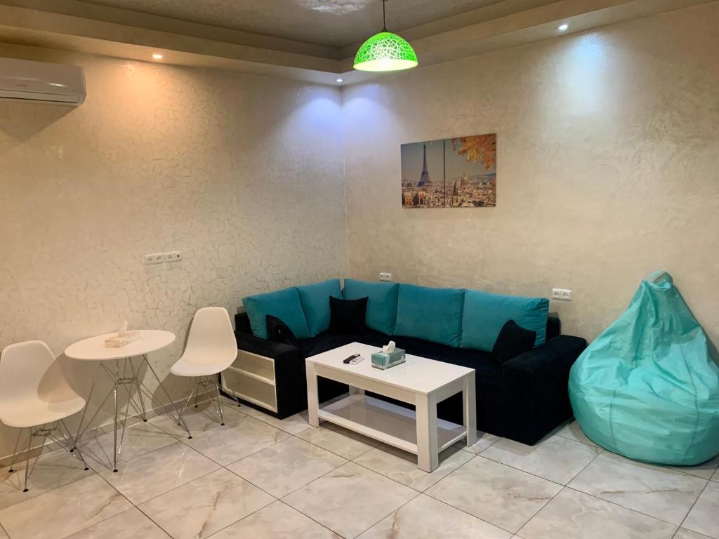 a living room with a blue couch and a table at Luxury Apartment with jacuzzi on Republic Square in Yerevan