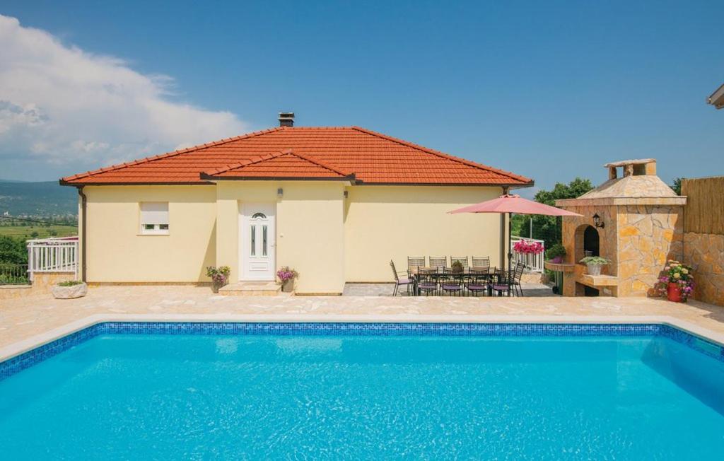 a villa with a swimming pool in front of a house at Villa Katarina in Zmijavci