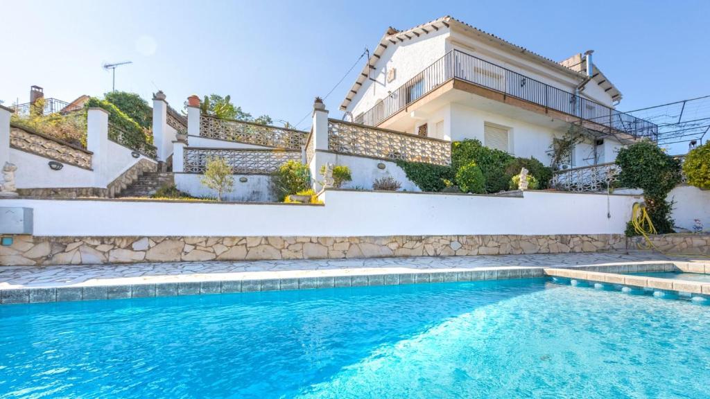 a villa with a swimming pool in front of a house at House - 3 Bedrooms with Pool and Sea views young people group not allowed - 8977 in Lloret de Mar