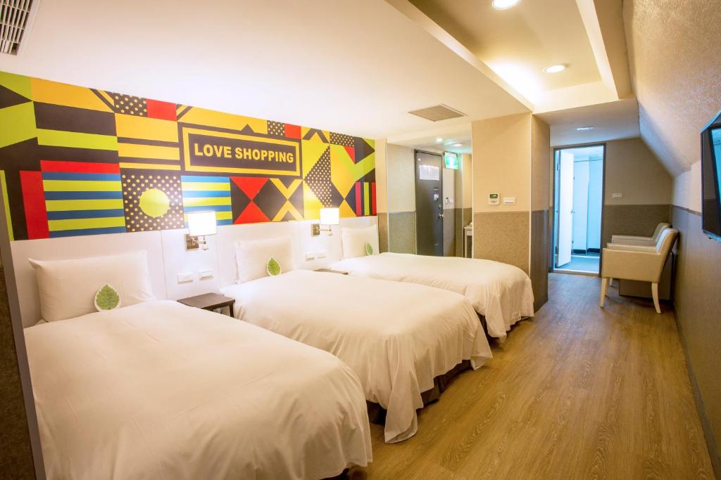 a room with three beds and a sign that reads love supreme at Ximen Citizen Hotel in Taipei