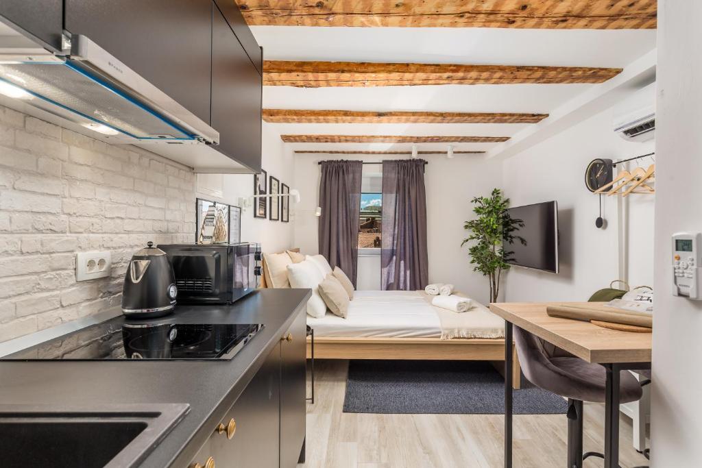 a kitchen and a living room with a couch at Grota apartment in the center 2 in Rijeka