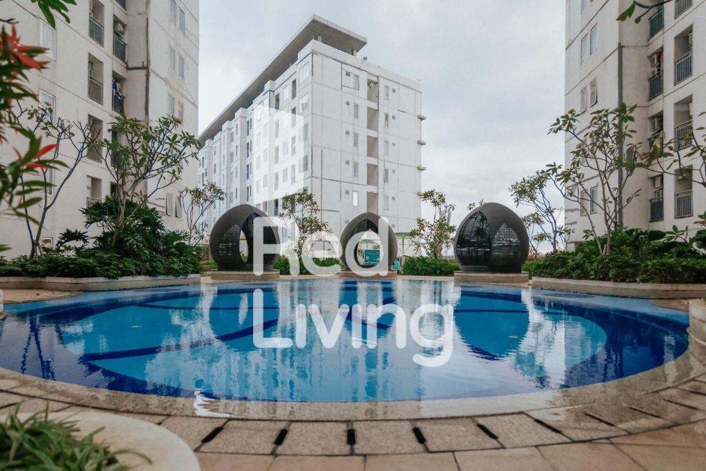 una piscina di fronte a un edificio di RedLiving Apartemen Bassura City - Vina Tan Tower Flamboyan a Giacarta
