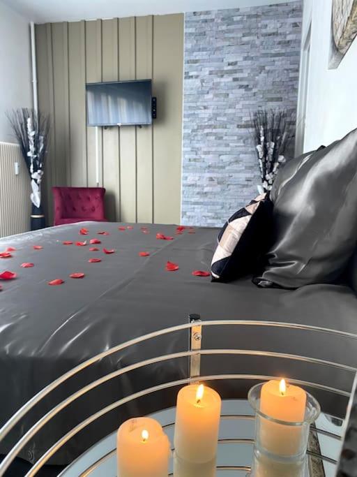 Dos velas colocadas sobre una mesa de cristal con una cama. en Le Charmant Studio Troyen, en Troyes