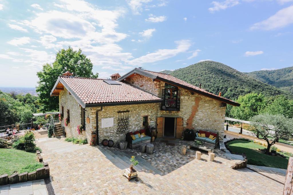 a stone house with a view of the mountains at AGRITURISMO CA' FENILE in Alzano Lombardo