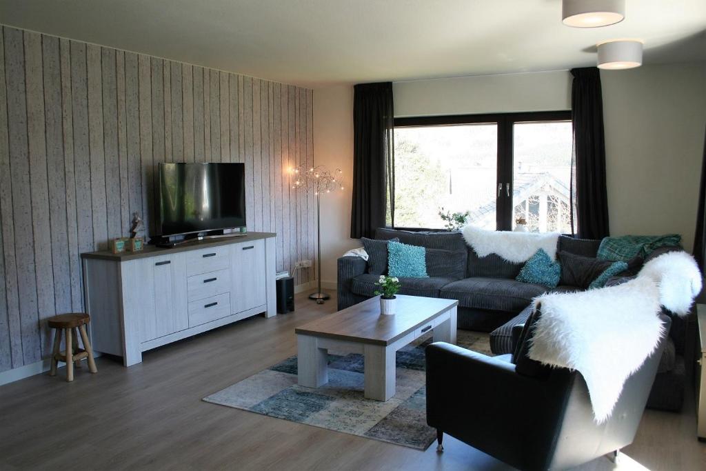 a living room with a couch and a tv at Auf der Platte 2 in Winterberg