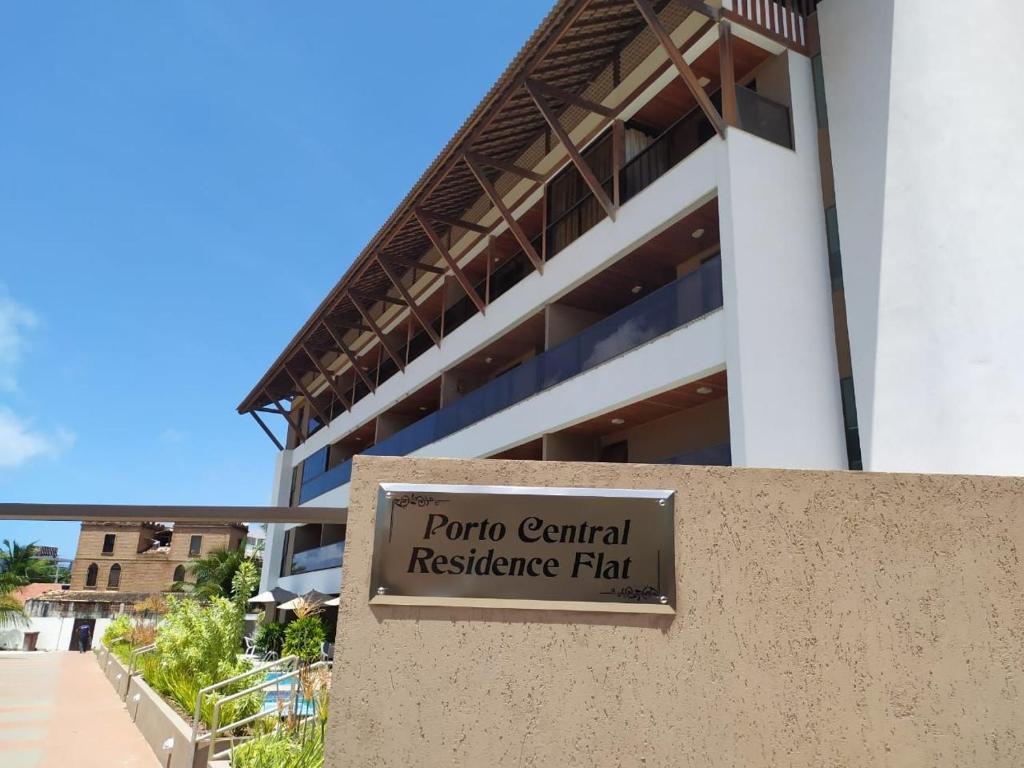 um sinal para um plano de resiliência central de venturi em frente a um edifício em Praia Central Porto de Galinhas em Porto de Galinhas