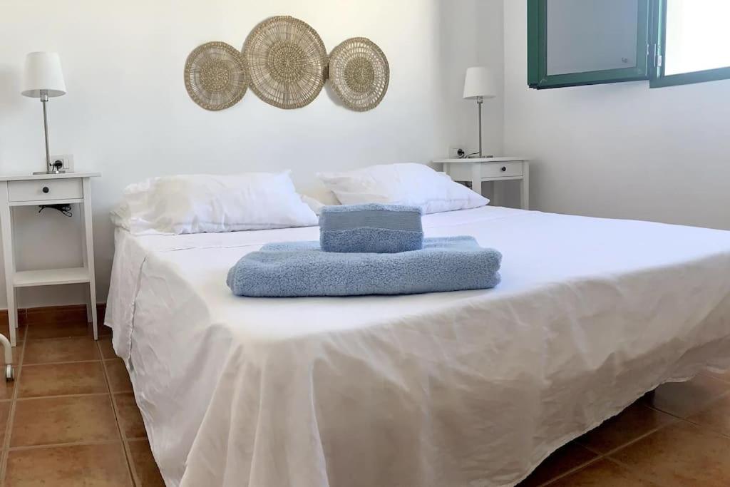 Una cama blanca con dos toallas encima. en Salitre Apartamento, en El Golfo