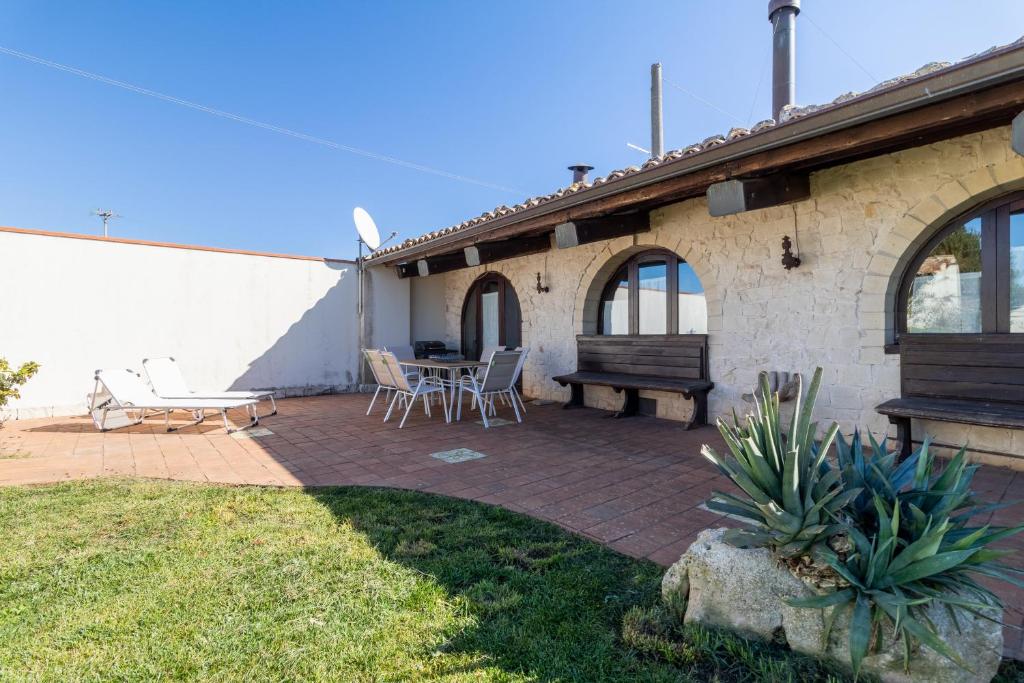 une terrasse avec un banc, une table et des chaises dans l'établissement Casa Vacanze Villa Giada Jacuzzi, à Raguse