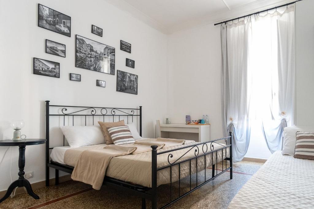 1 dormitorio con cama negra y cuadros en la pared en Zaira b&b en Roma