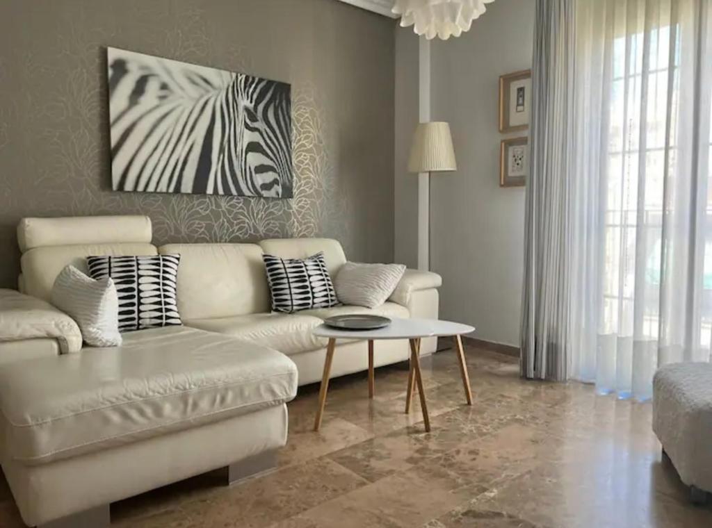 una sala de estar con un sofá blanco y una pintura de cebra en Apartamento Puente Romano con Parking gratuito, en Córdoba