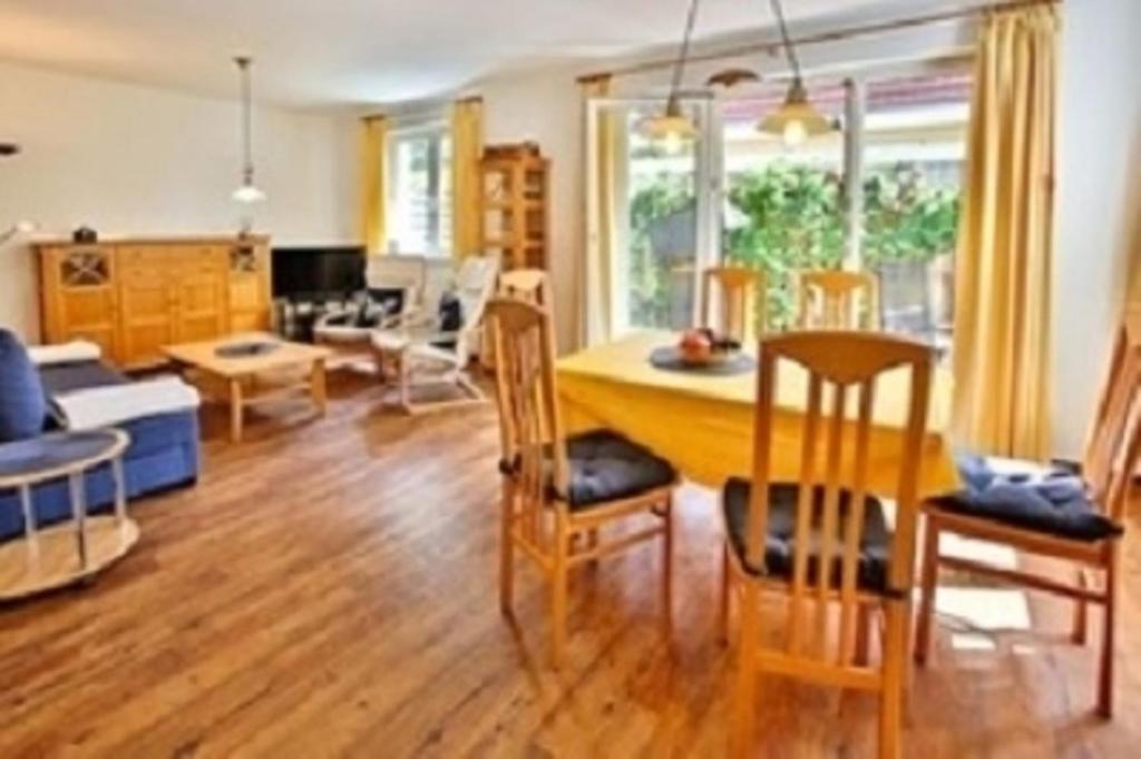 uma cozinha e sala de estar com mesa e cadeiras em Meeresrauschen - a72292 em Neuhaus