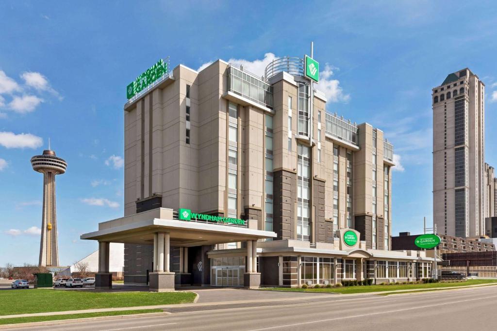 a hotel building with a tower in the background at Wyndham Garden Niagara Falls Fallsview in Niagara Falls