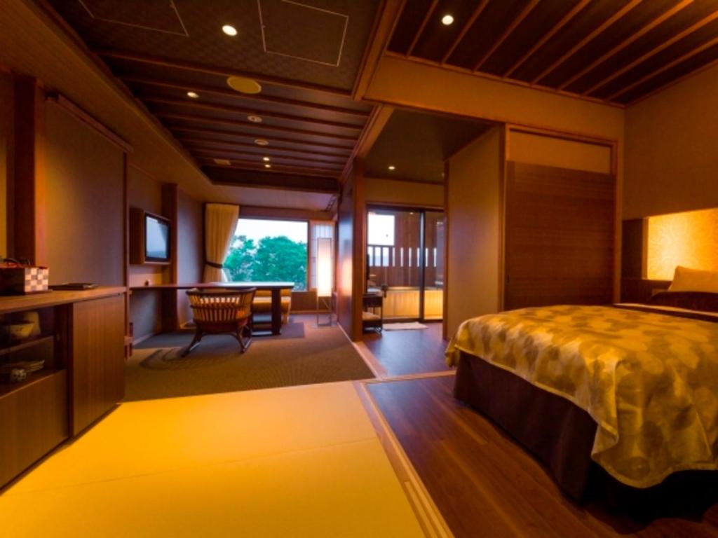 a bedroom with a bed and a desk and a table at Bessho Sasa in Fujiyoshida