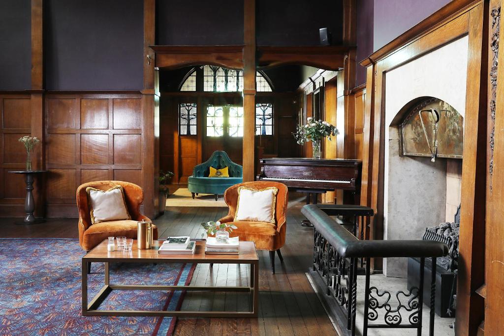 a living room with a piano and a table at Elmbank Hotel - Part of The Cairn Collection in York