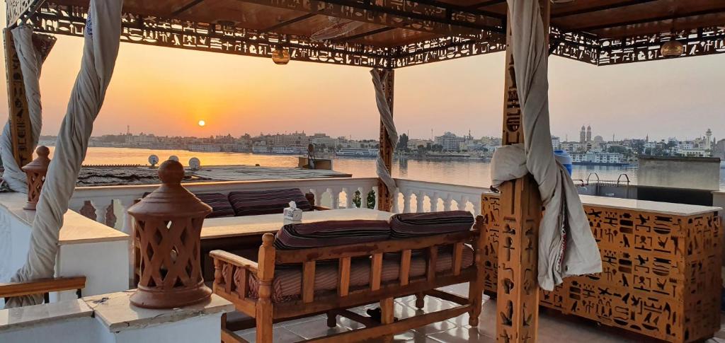 einen Tisch auf dem Balkon mit Blick auf den Sonnenuntergang in der Unterkunft Nile Sunrise Flats in Luxor