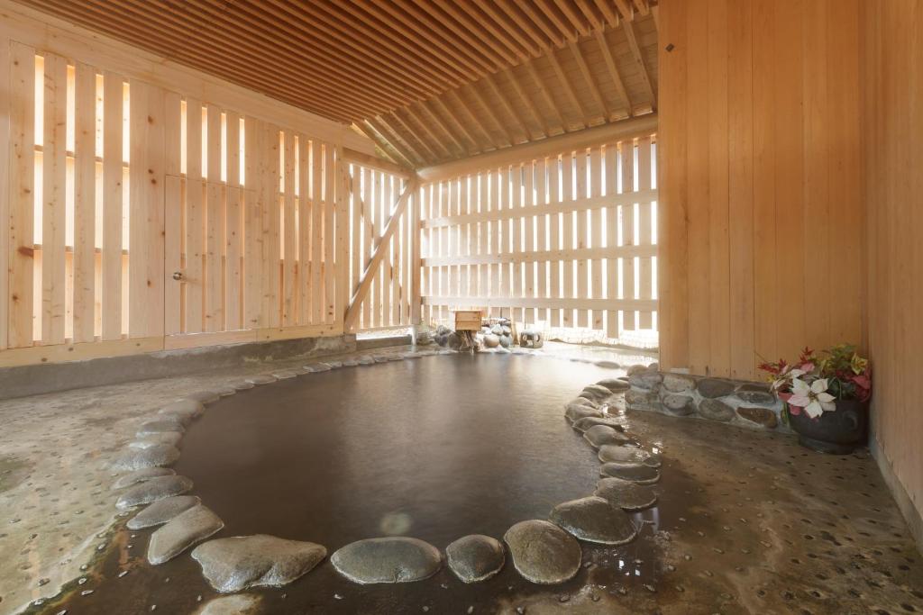une grande chambre avec piscine d'eau dans un bâtiment dans l'établissement Dai Onsen Matsudaya Ryokan, à Hanamaki