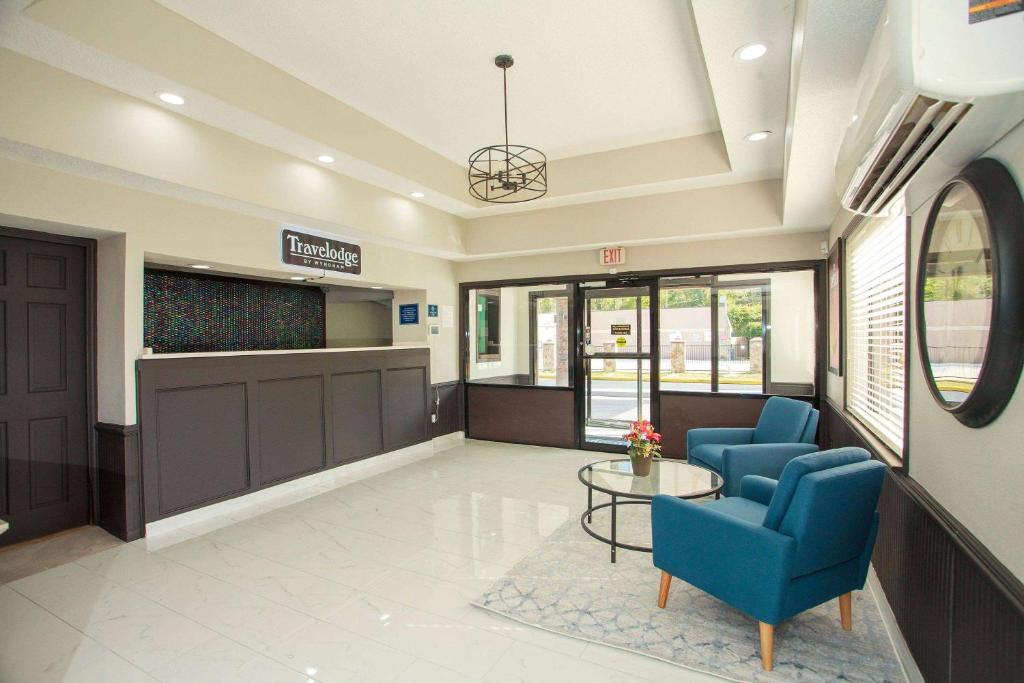 una sala de espera en un hospital con sillas azules y una mesa en Travelodge by Wyndham Macon West, en Macon