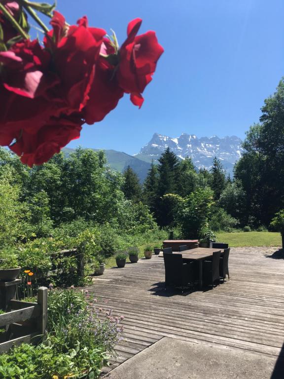 a picnic table and benches in a park with mountains at Chalet Ingas in Troistorrents