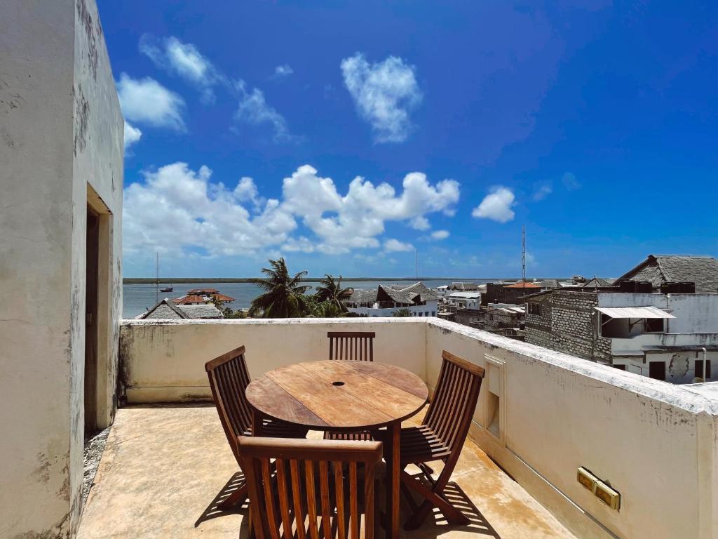 a table and chairs on a balcony with a view of the ocean at Lamu penthouse Apartment in Lamu