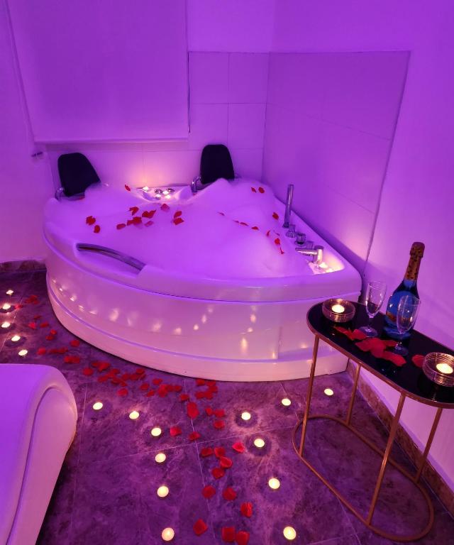 a purple room with a tub with a bottle of champagne at Apartamento Love Jacuzzi in Cartagena
