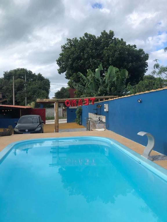 a large blue swimming pool in a parking lot at Suites piscina Búzios in Búzios