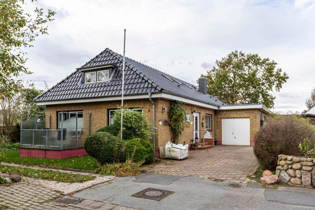 ein Backsteinhaus mit schwarzem Dach in der Unterkunft Heidi in Tönning