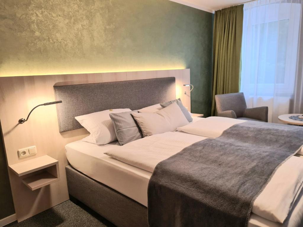 ein Hotelzimmer mit einem Bett und einem Stuhl in der Unterkunft Verwöhn-Pension Wiesengrund in Bischofsgrün